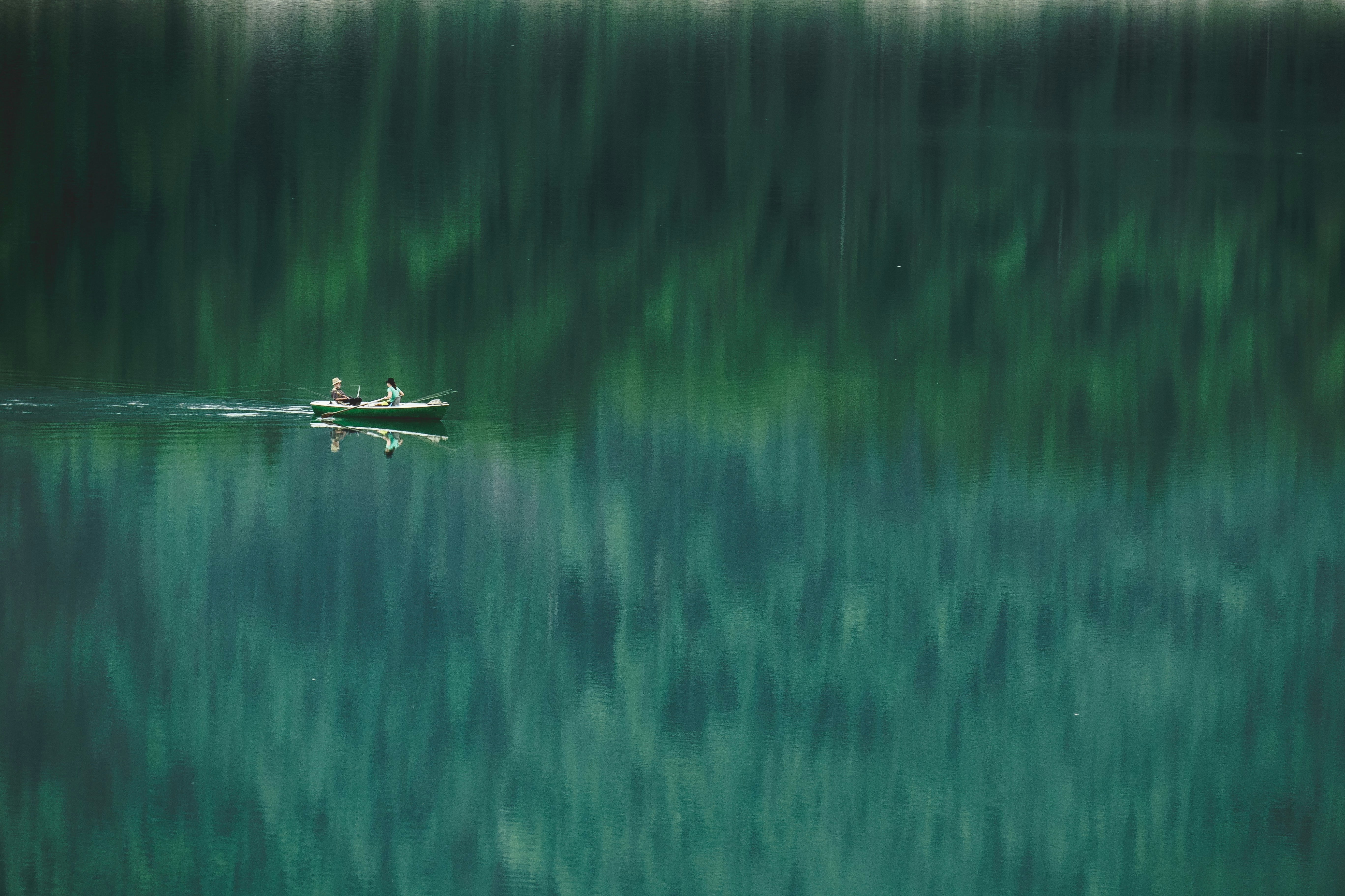 person riding on boat on body of water during daytime